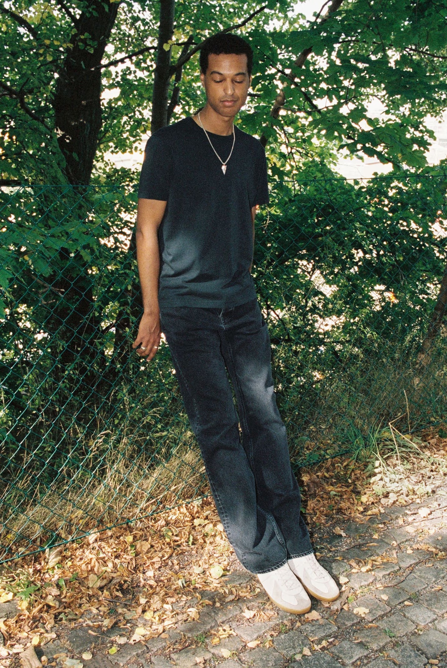 Man standing outdoors with greenery in the background