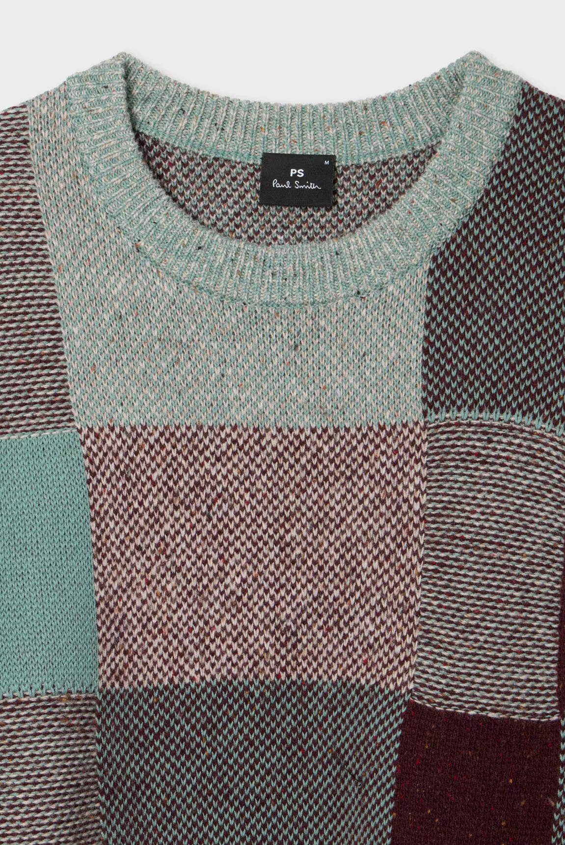 Patchwork sweater with a brand label on a white background