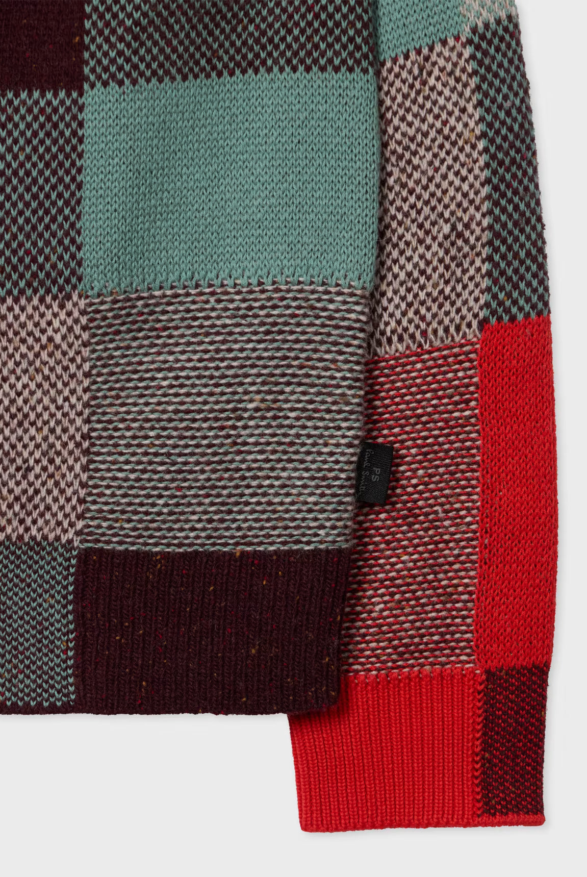 Close-up of a plaid fabric with red, green, and brown colors on a white background.