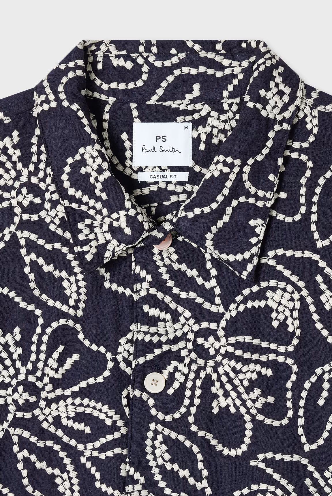 Navy shirt with white pattern and Paul Smith label on a light gray background