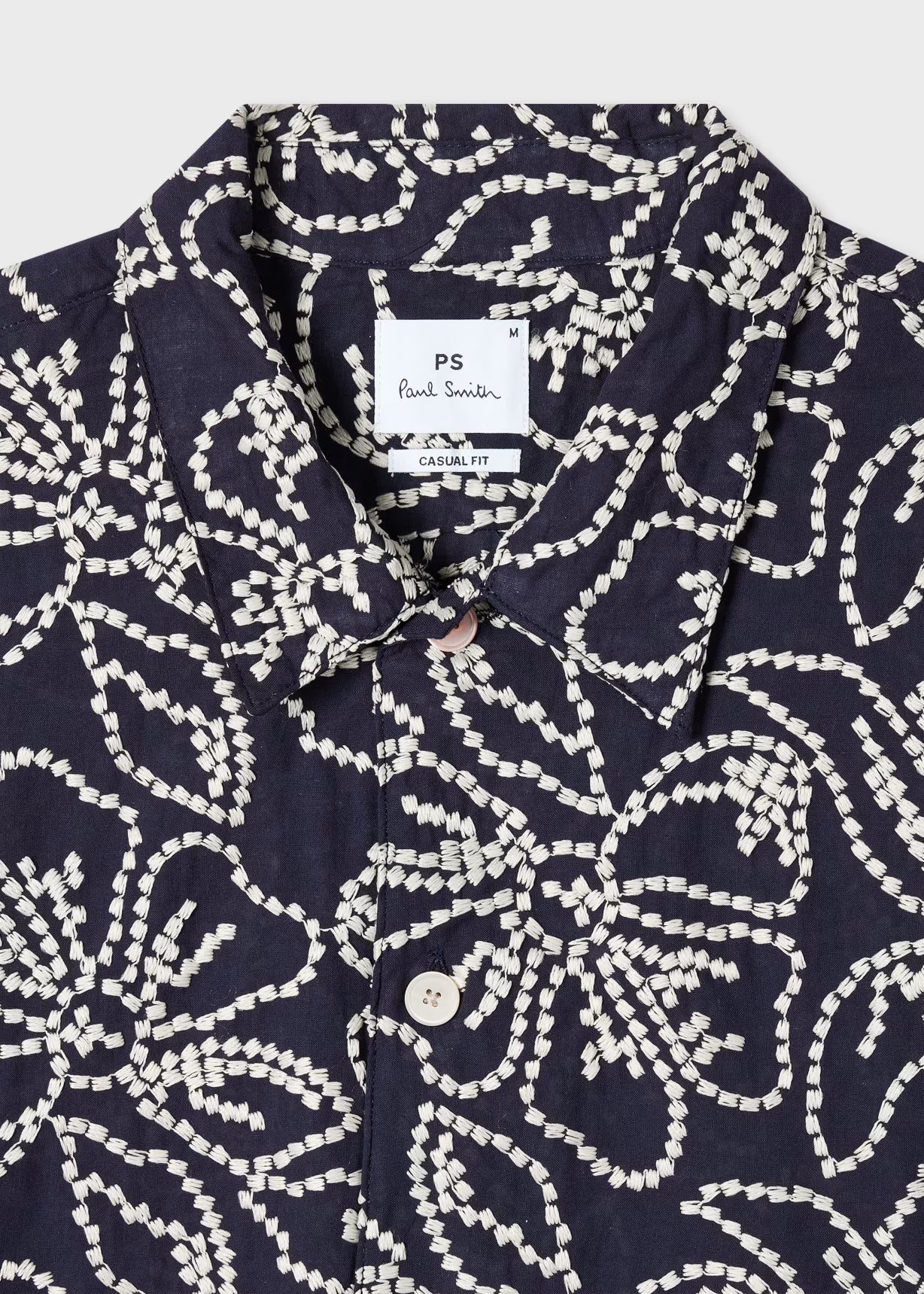 Navy shirt with white pattern and Paul Smith label on a light gray background
