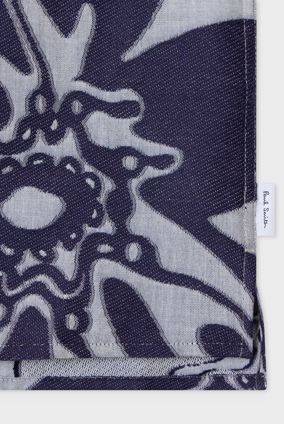 Navy blue and gray patterned fabric with a brand label on a white background
