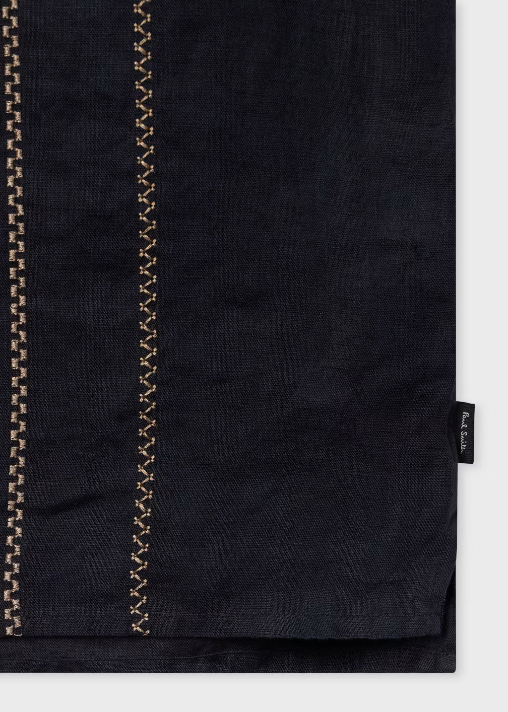 Black fabric with gold stitching on a white background