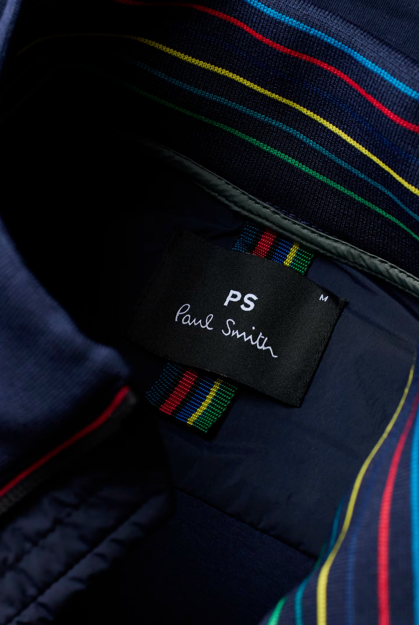 Close-up of a Paul Smith label on a garment with colorful stripes.
