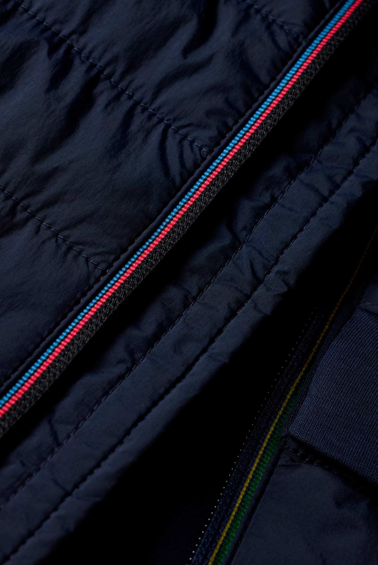 Close-up of a navy blue jacket with zipper details