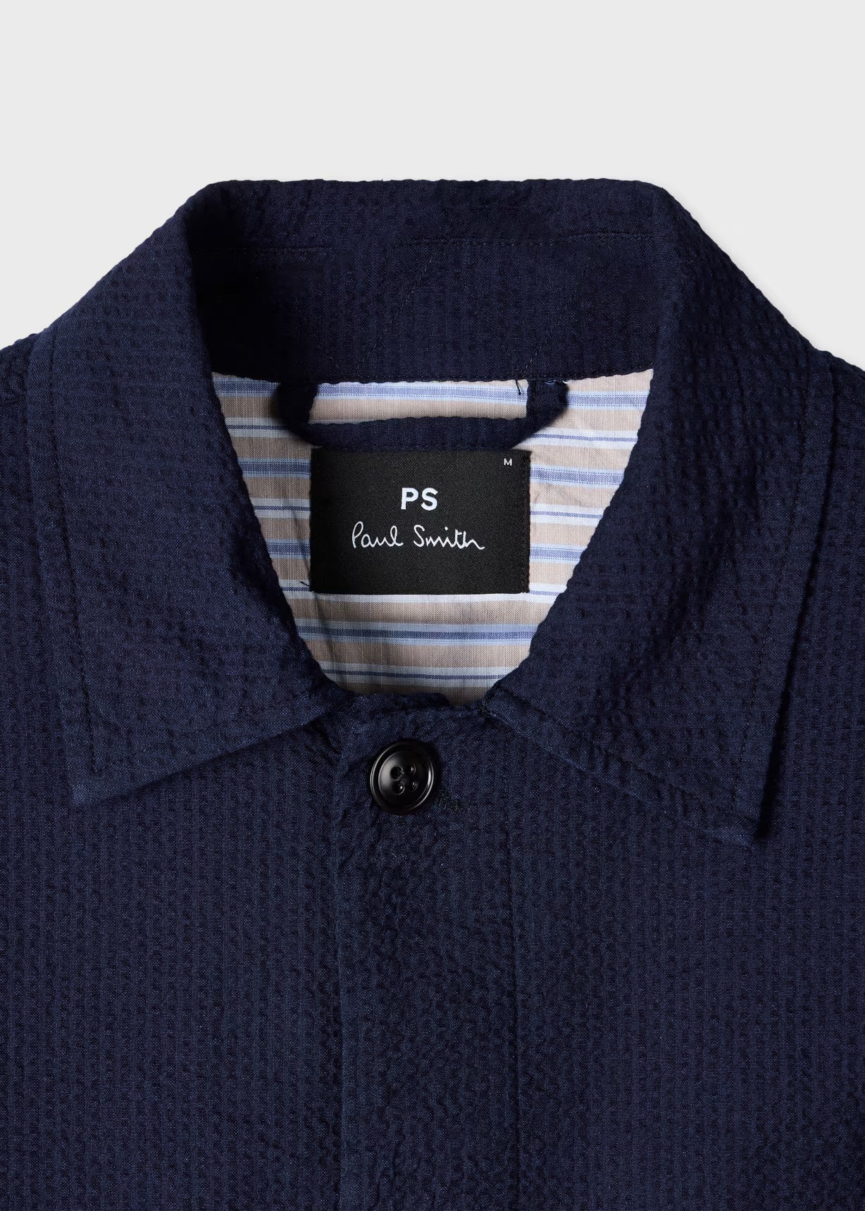Navy blue textured shirt with a Paul Smith label on a light gray background