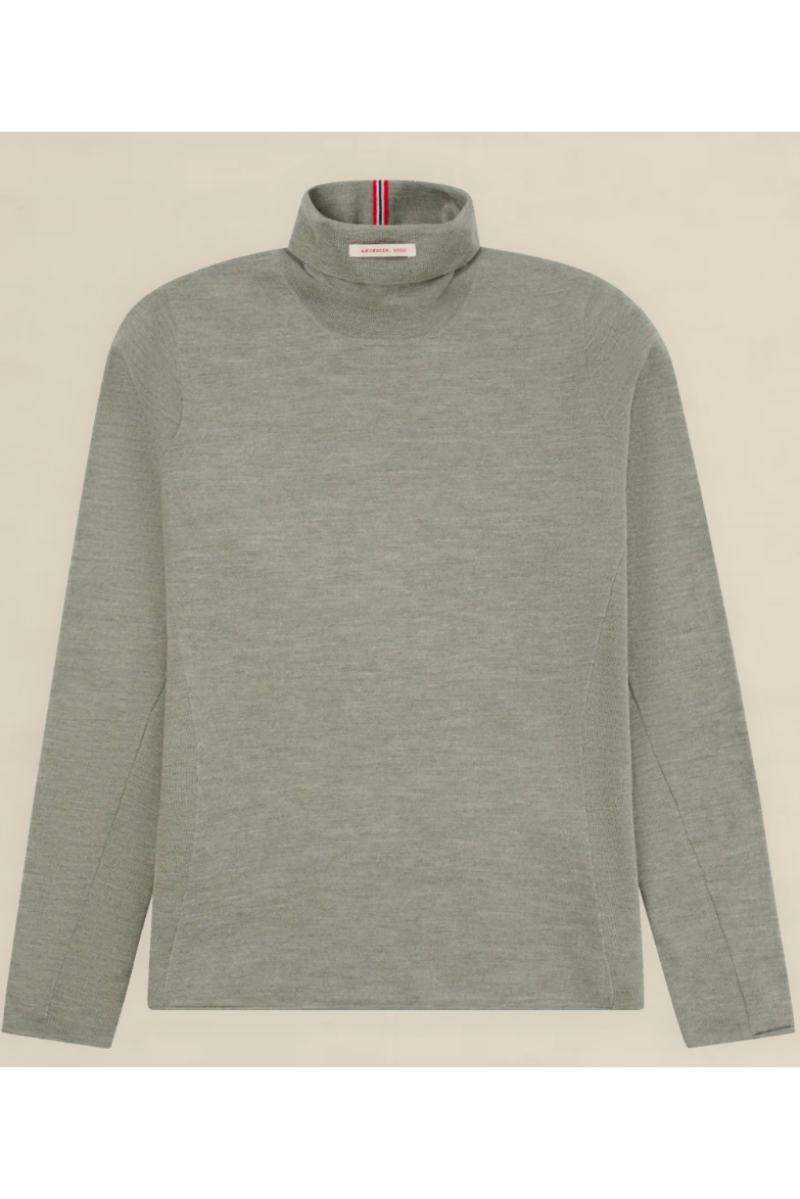 A light gray long-sleeve mock neck sweater with a subtle heathered texture, laid flat against a light beige background. A small red, white, and blue striped brand tag is visible inside the collar.