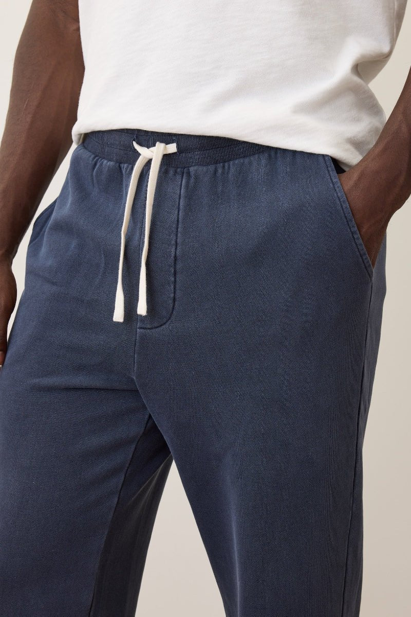 Navy blue pants with a white drawstring on a neutral background