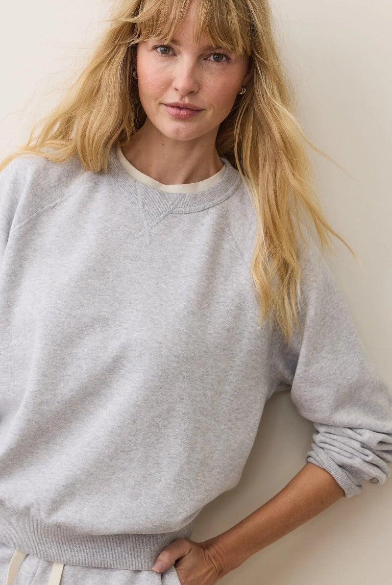 Woman wearing a gray sweatshirt against a plain background