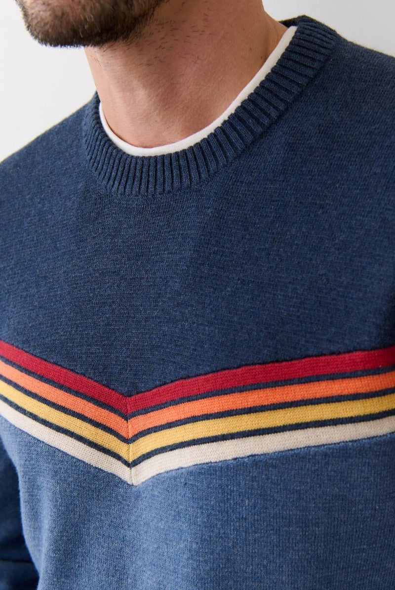 Blue sweater with colorful stripes worn by a person