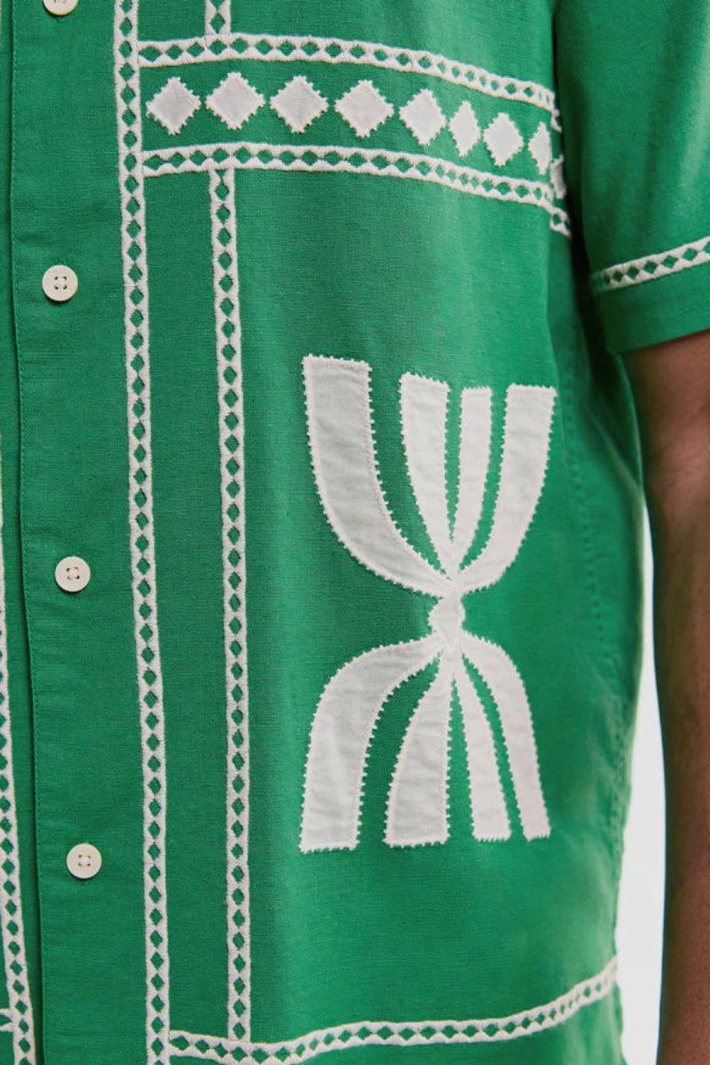 Green shirt with white embroidery on a person