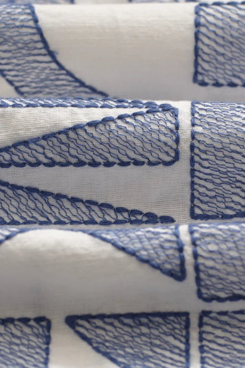 Close-up of blue geometric pattern on white fabric