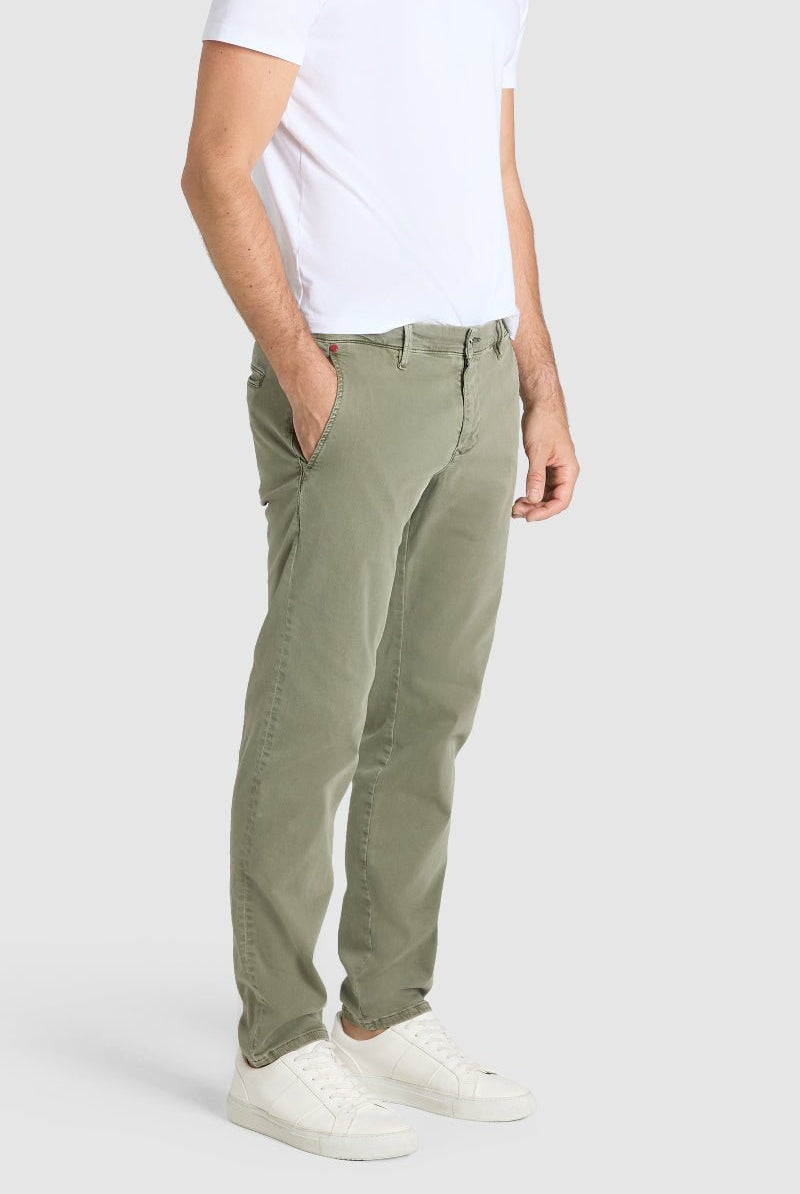 Person wearing olive green pants and a white shirt on a plain background