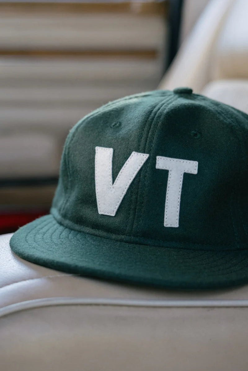 Green cap with 'VT' on a car seat