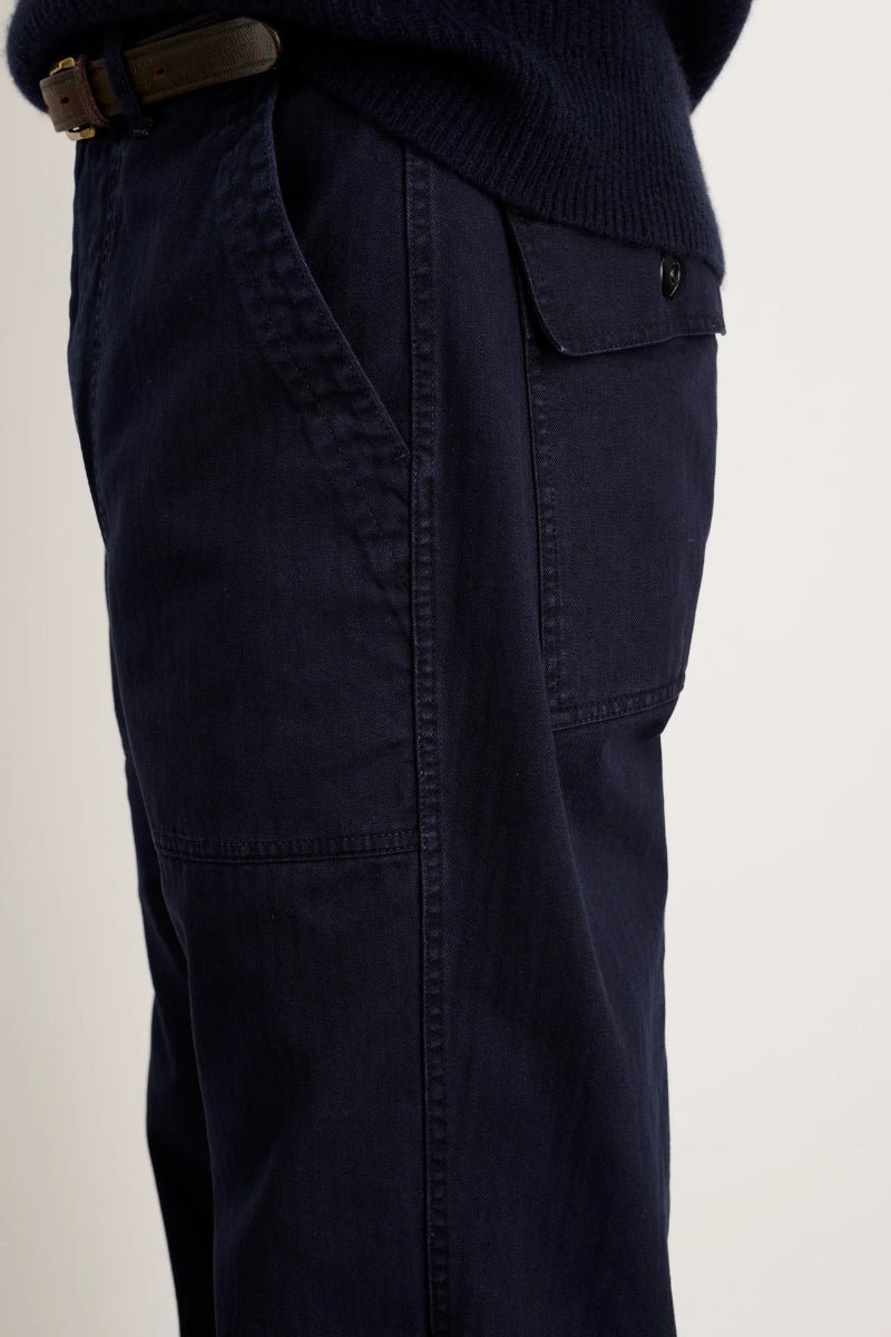 Navy blue pants with a belt on a beige background