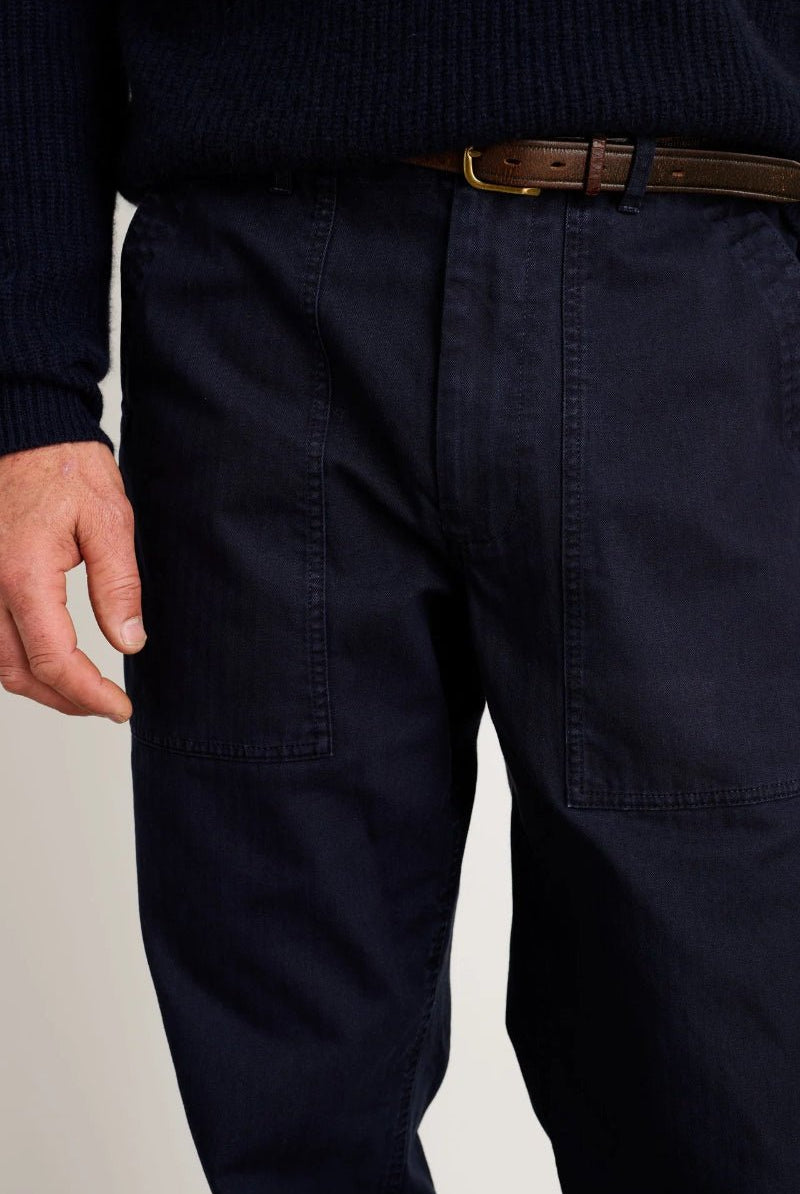 Navy pants worn by a person on a plain background
