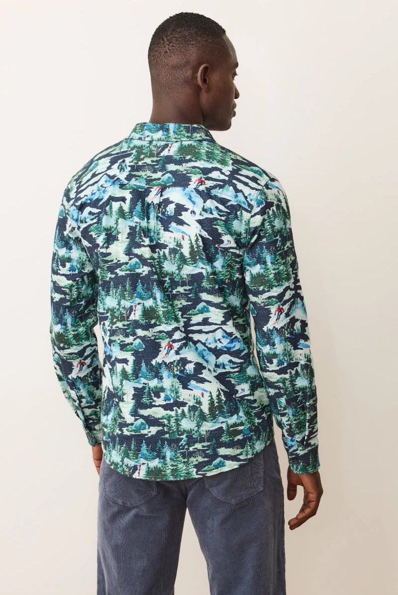 Man wearing a long-sleeve shirt with a green and blue abstract pattern on a plain background