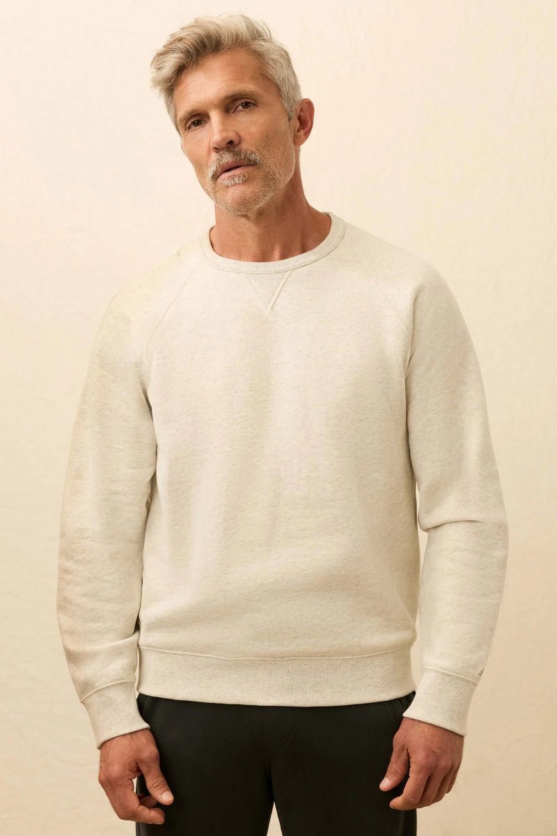 Man wearing a beige sweater against a beige background