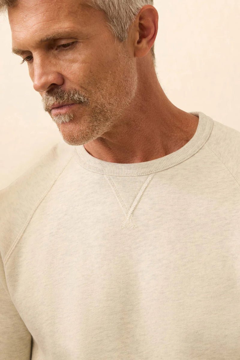 Man wearing a beige sweater against a neutral background