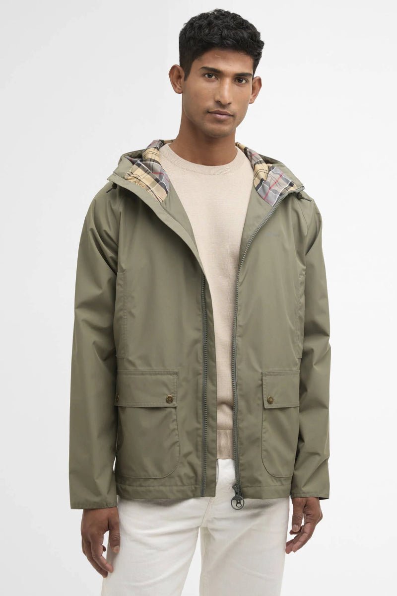 Man wearing a green jacket with a patterned hood on a white background