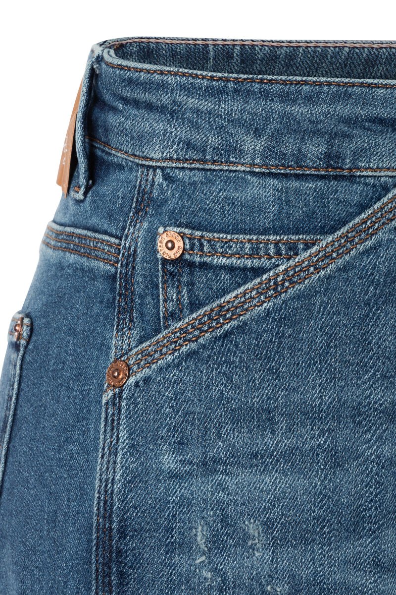 Close-up of blue jeans with stitching details on a white background
