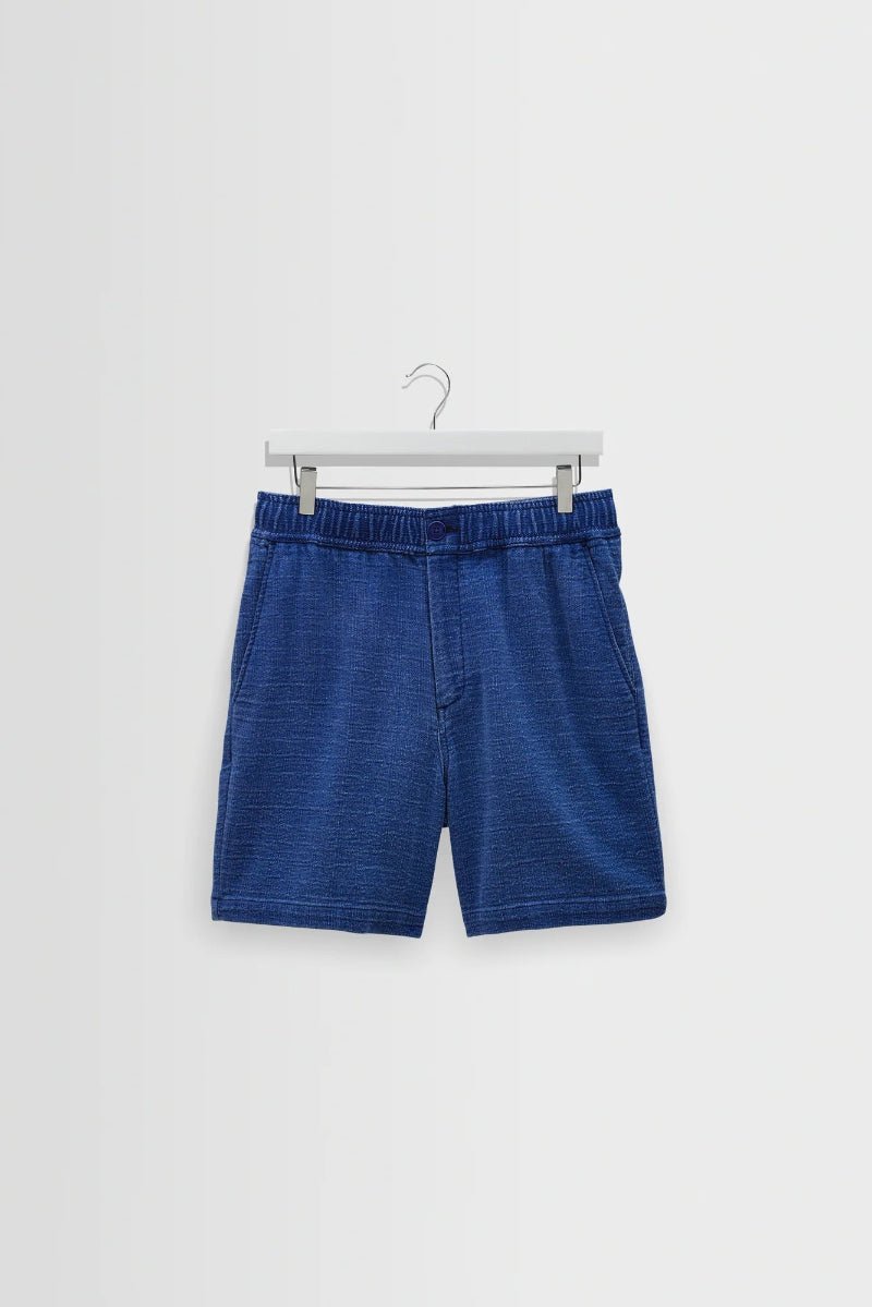 Blue shorts on a hanger against a white background
