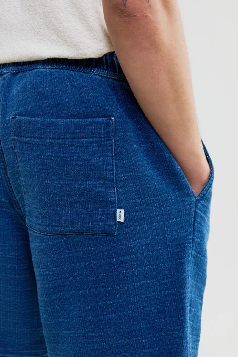 Blue shorts with a pocket and brand logo on a white background