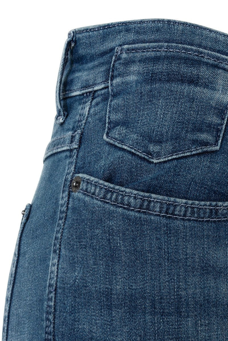 Close-up of blue denim jeans with a focus on the back pocket.