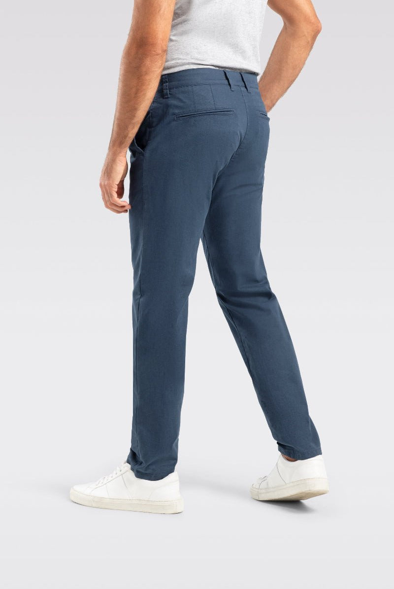 Person wearing blue pants and white shoes on a light gray background