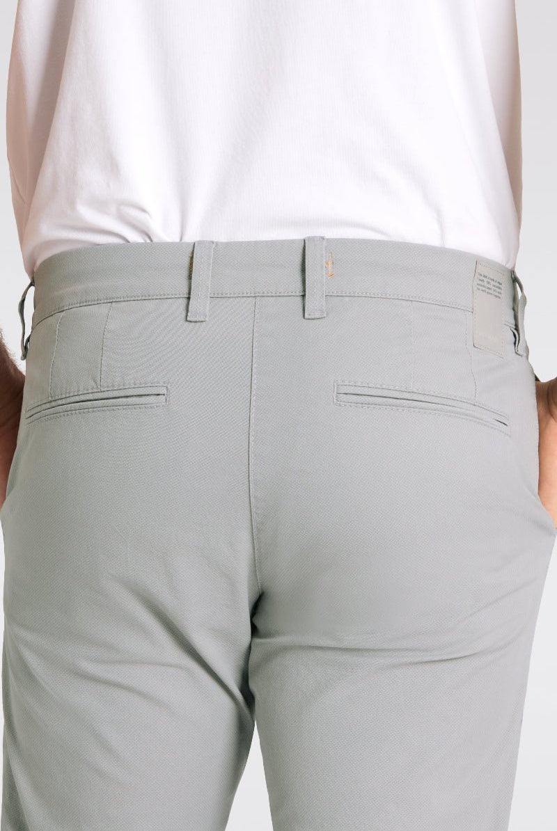 Light gray pants worn by a person on a white background