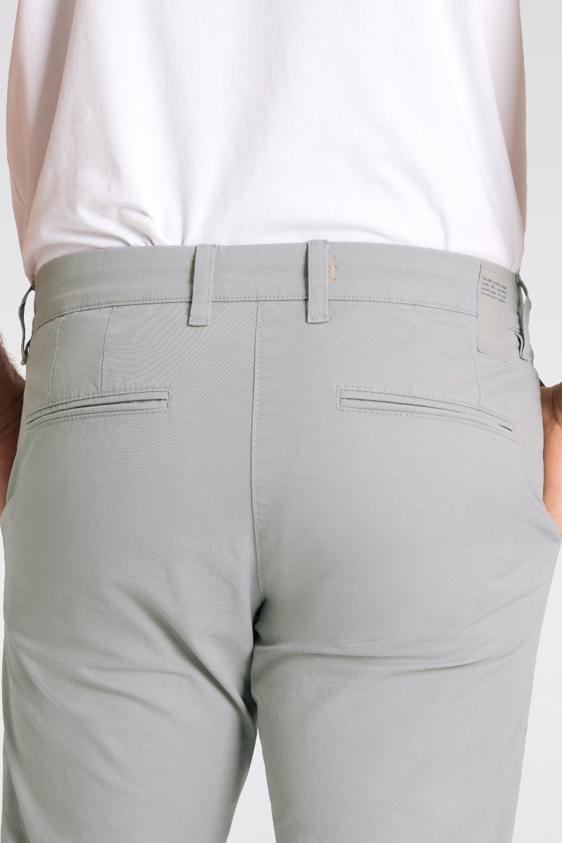 Light gray pants worn by a person on a white background