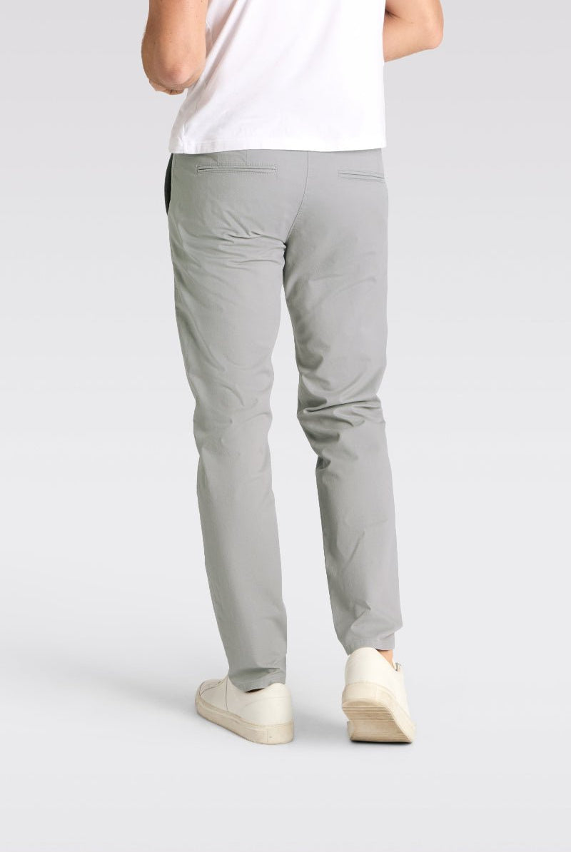Person wearing light gray pants on a plain background