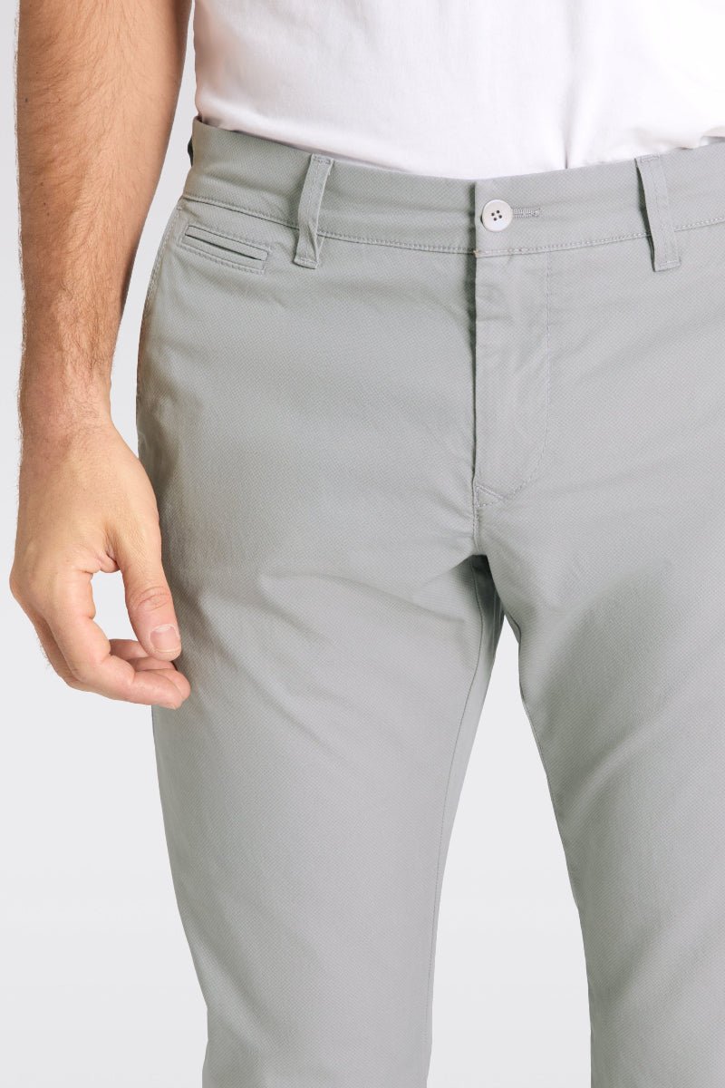Light gray pants worn by a person on a plain background