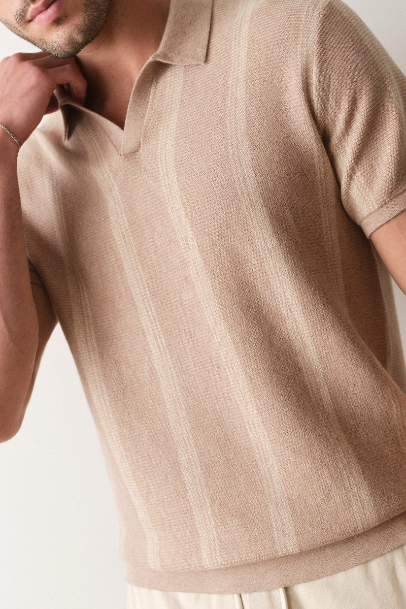 Man wearing a beige knitted polo shirt against a neutral background