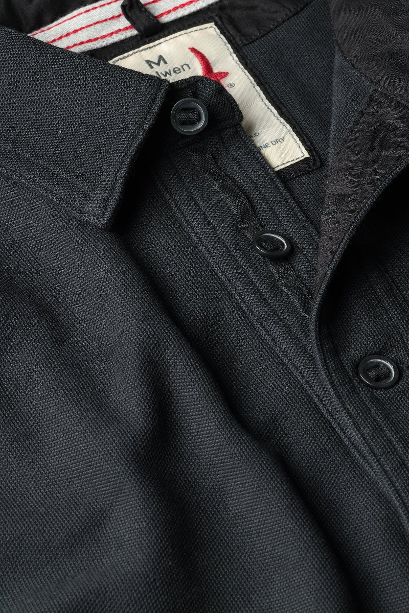 Close-up of a black jacket with a brand label on the collar.