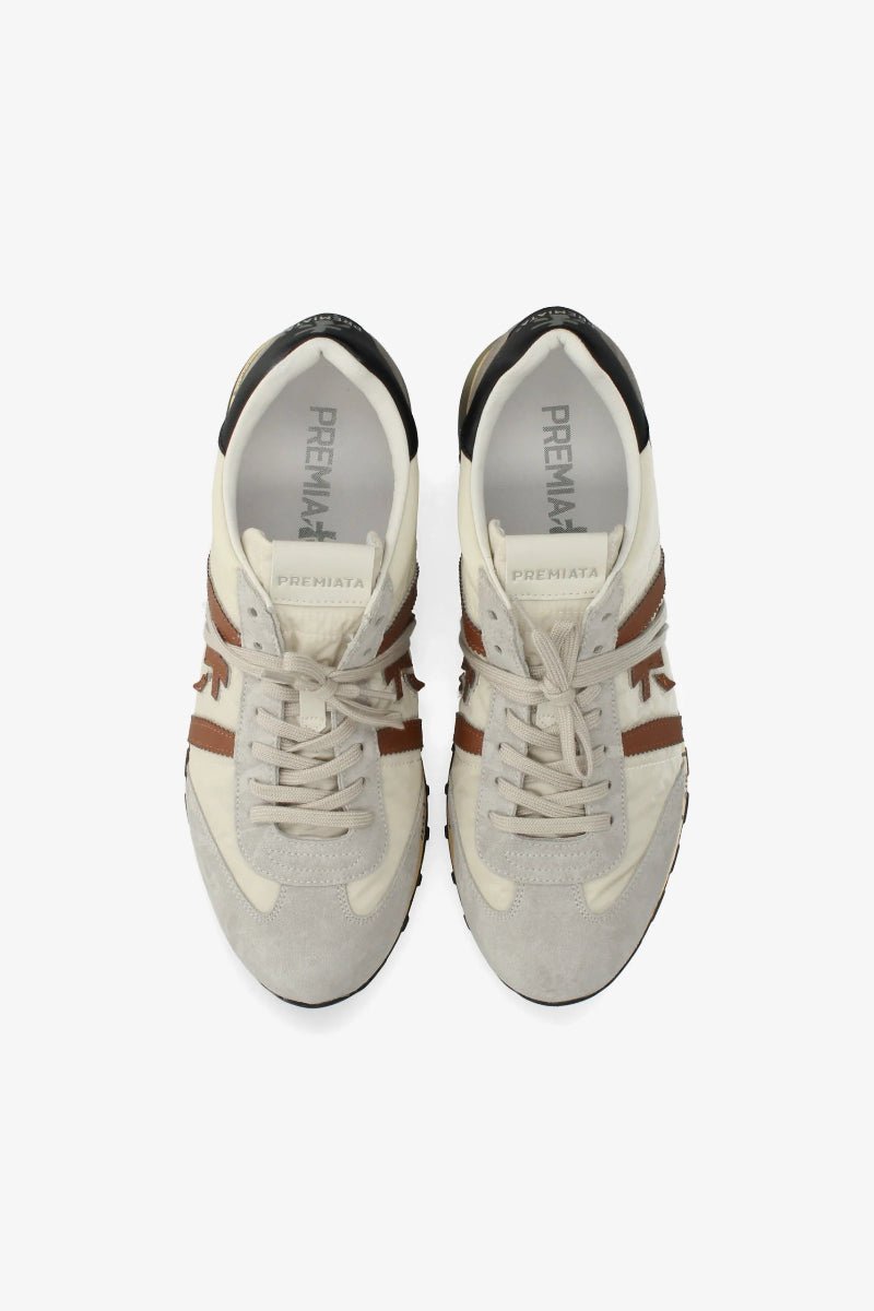 Pair of white sneakers with brown accents on a white background
