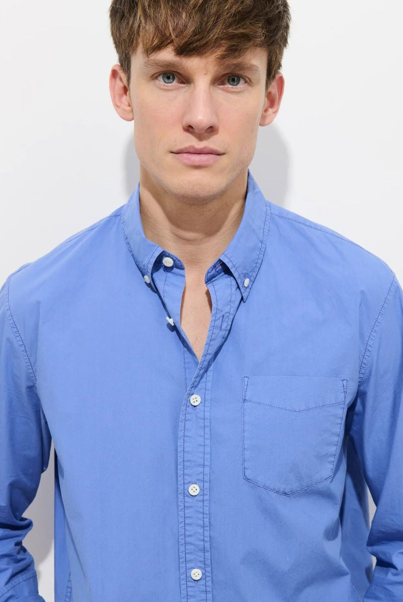 Man wearing a blue shirt against a white background