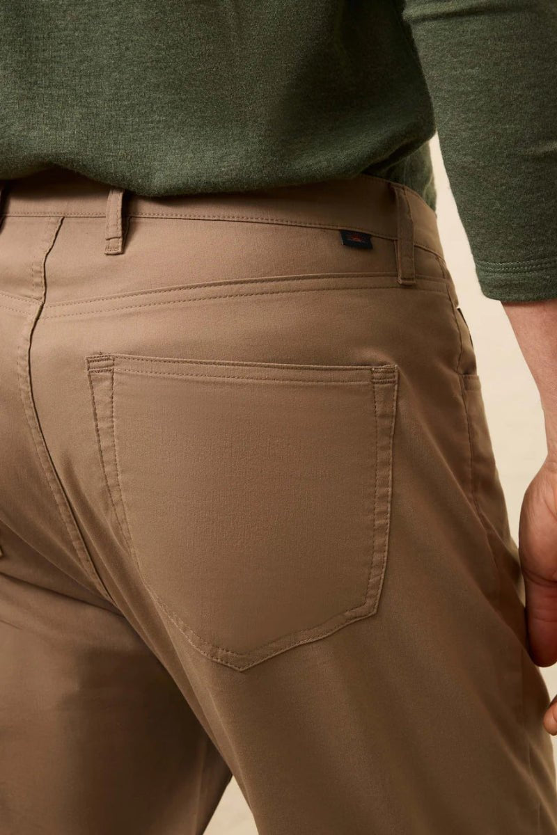 Brown pants worn by a person with a green shirt on a beige background