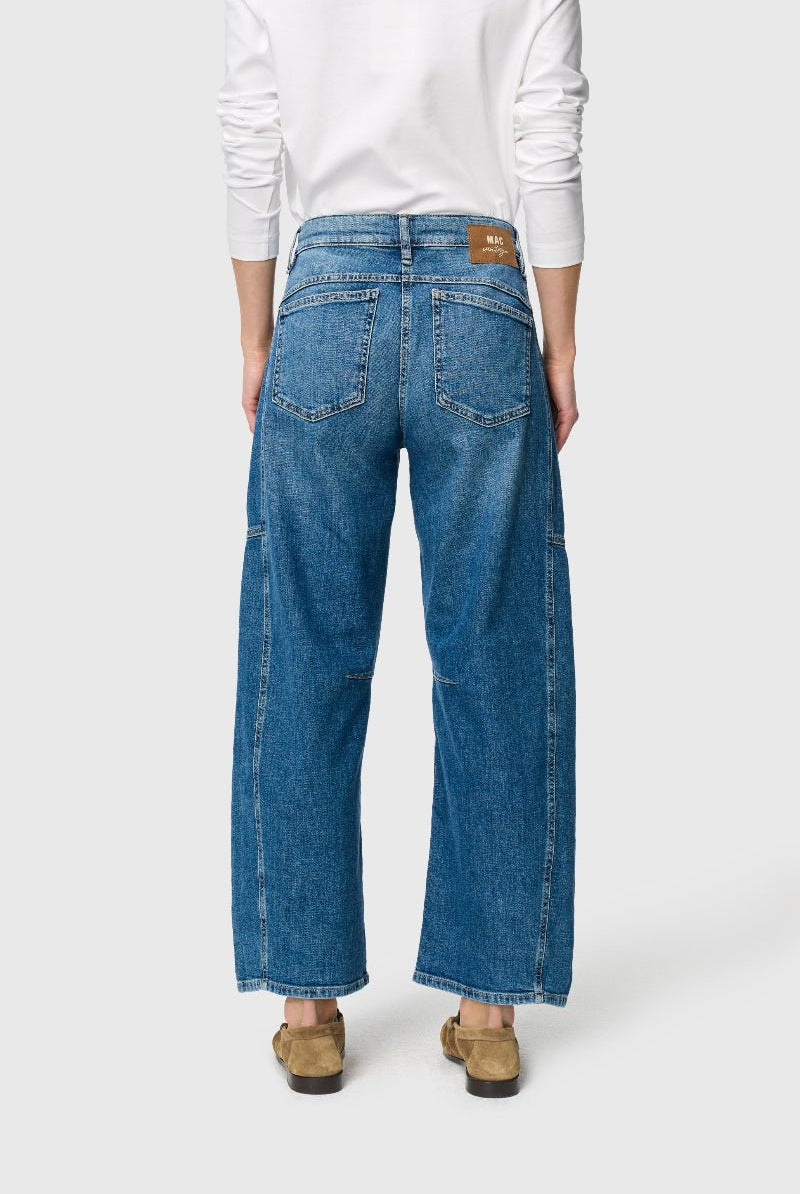 Person wearing blue jeans on a white background