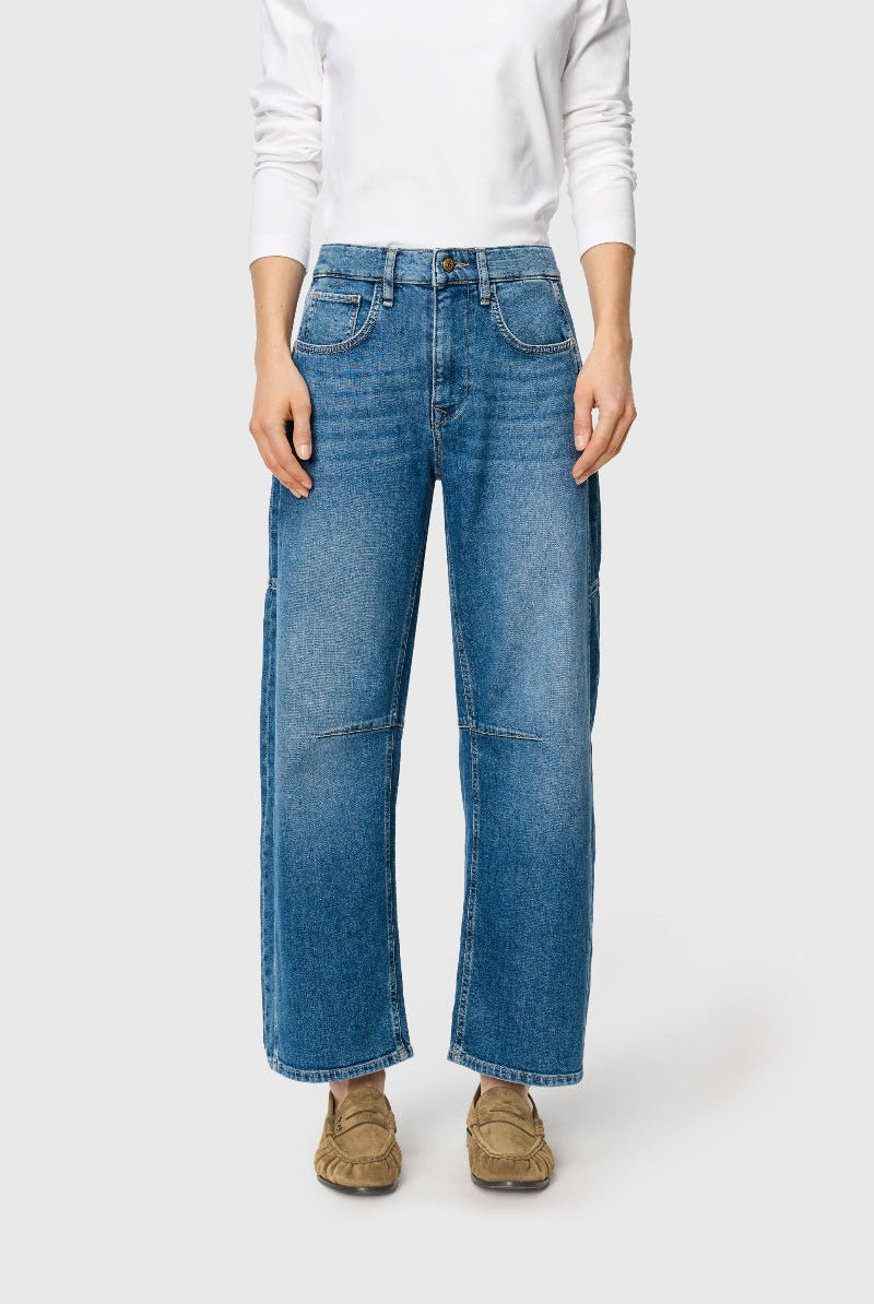 Person wearing blue jeans and a white sweater on a white background