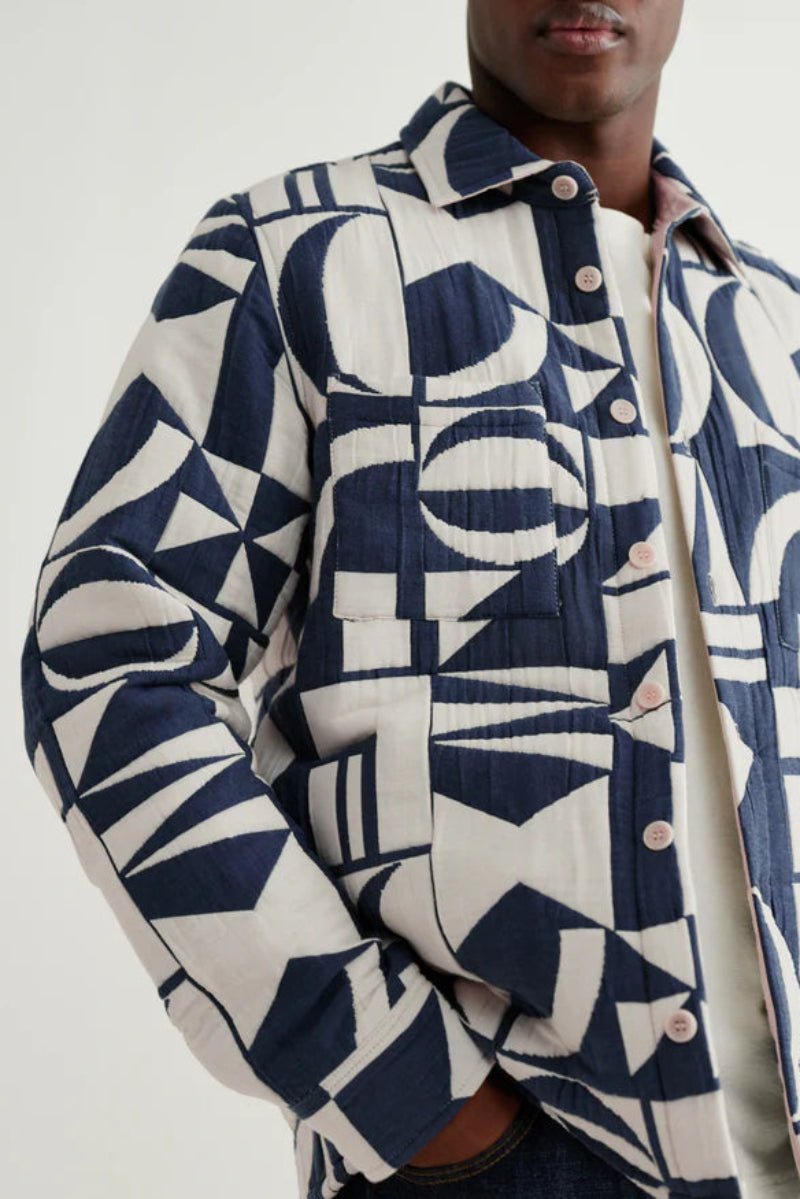 Person wearing a blue and white patterned jacket on a plain background