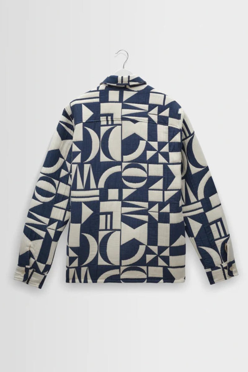 Geometric patterned shirt on a hanger against a white background