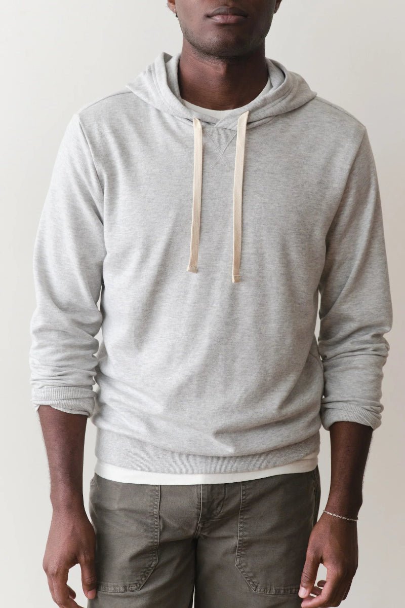 Person wearing a gray hoodie with a plain background