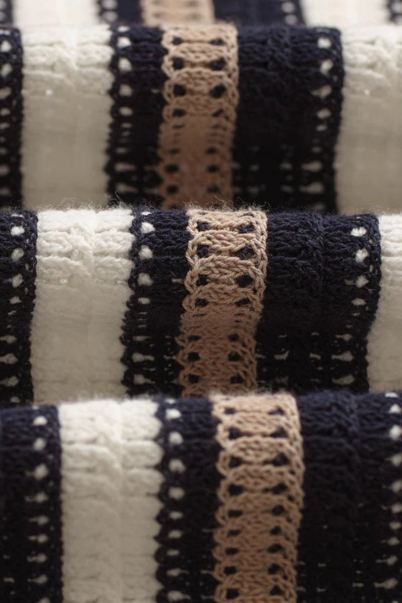 Close-up of striped fabric with black, beige, and white pattern