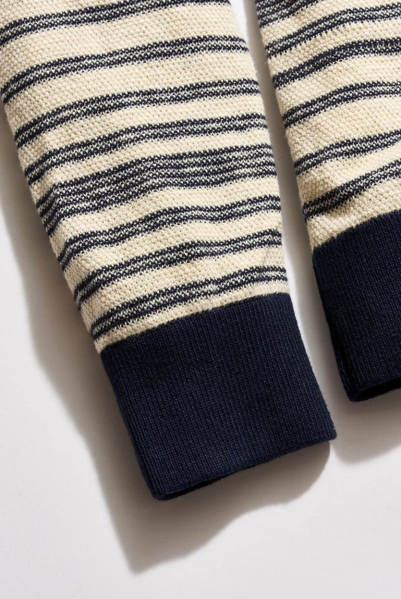 Close-up of striped sleeves with navy cuffs on a light background