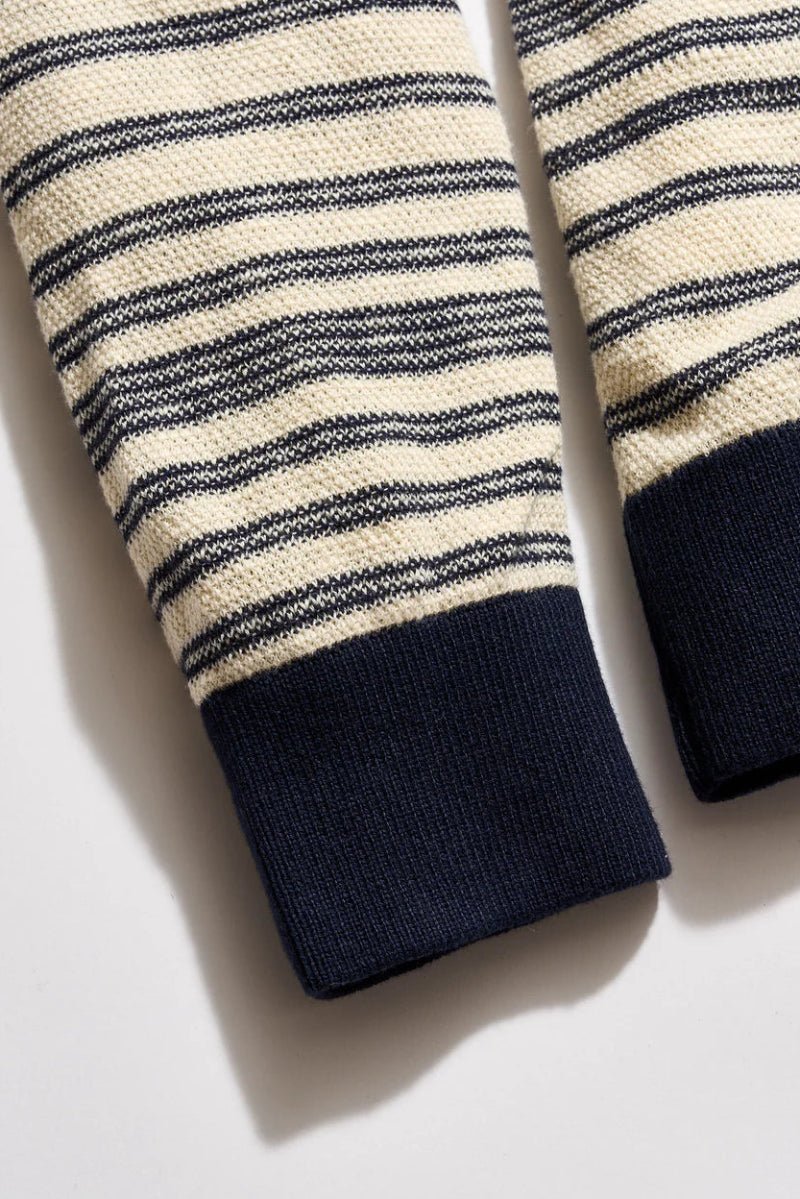 Close-up of striped sleeves with navy cuffs on a light background