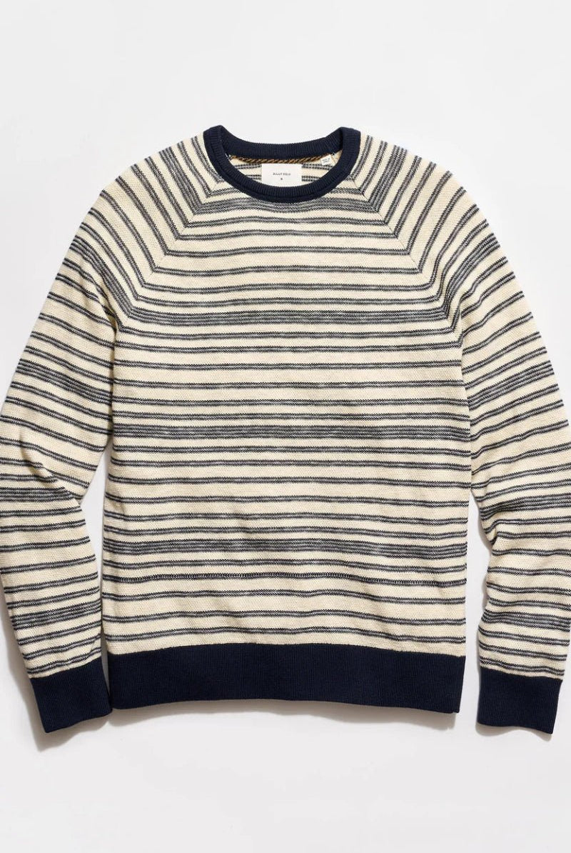 Striped sweater with navy and white stripes on a light gray background