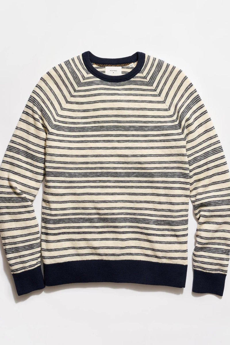 Striped sweater with navy and white stripes on a light gray background