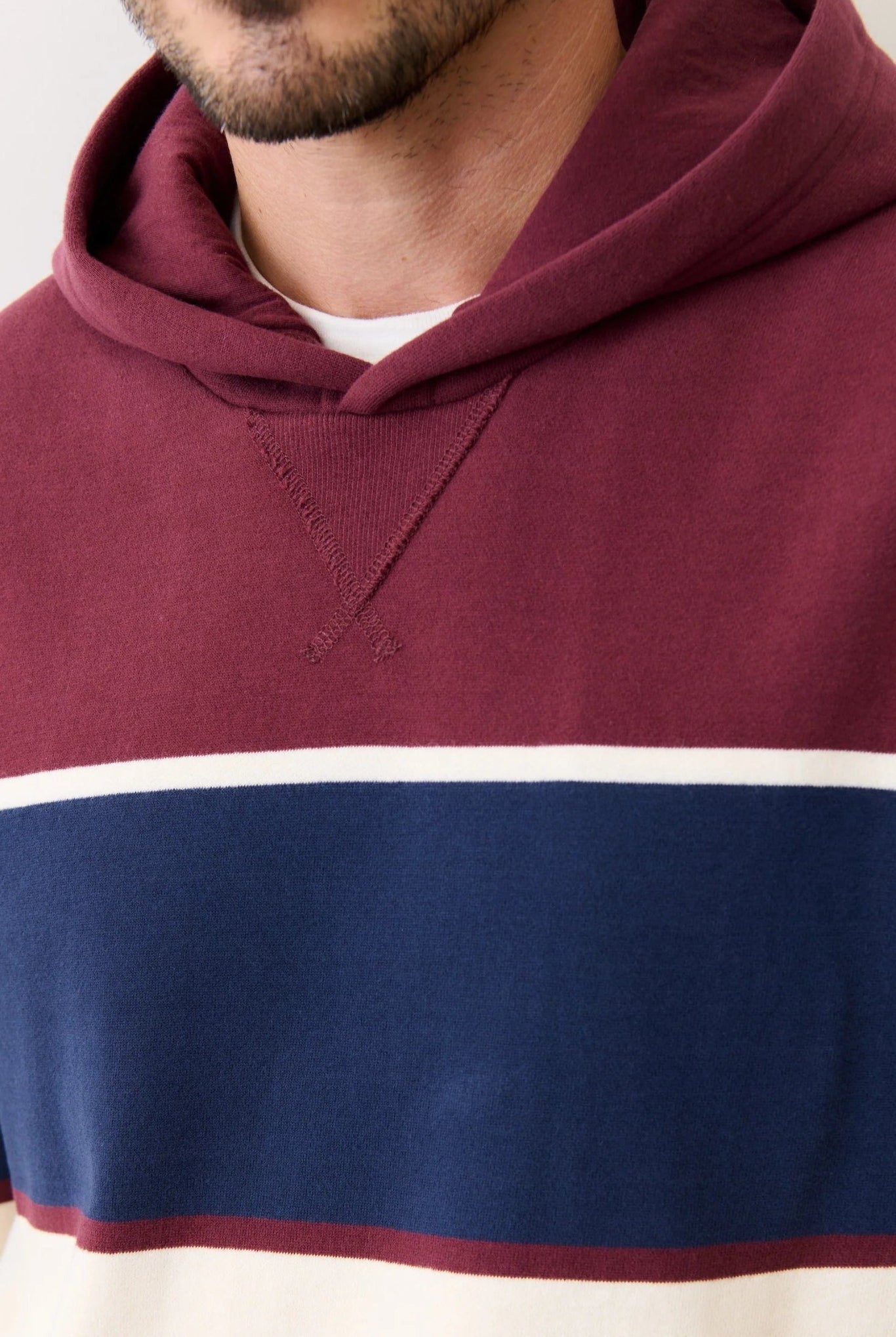 Maroon, blue, and white striped hoodie worn by a person