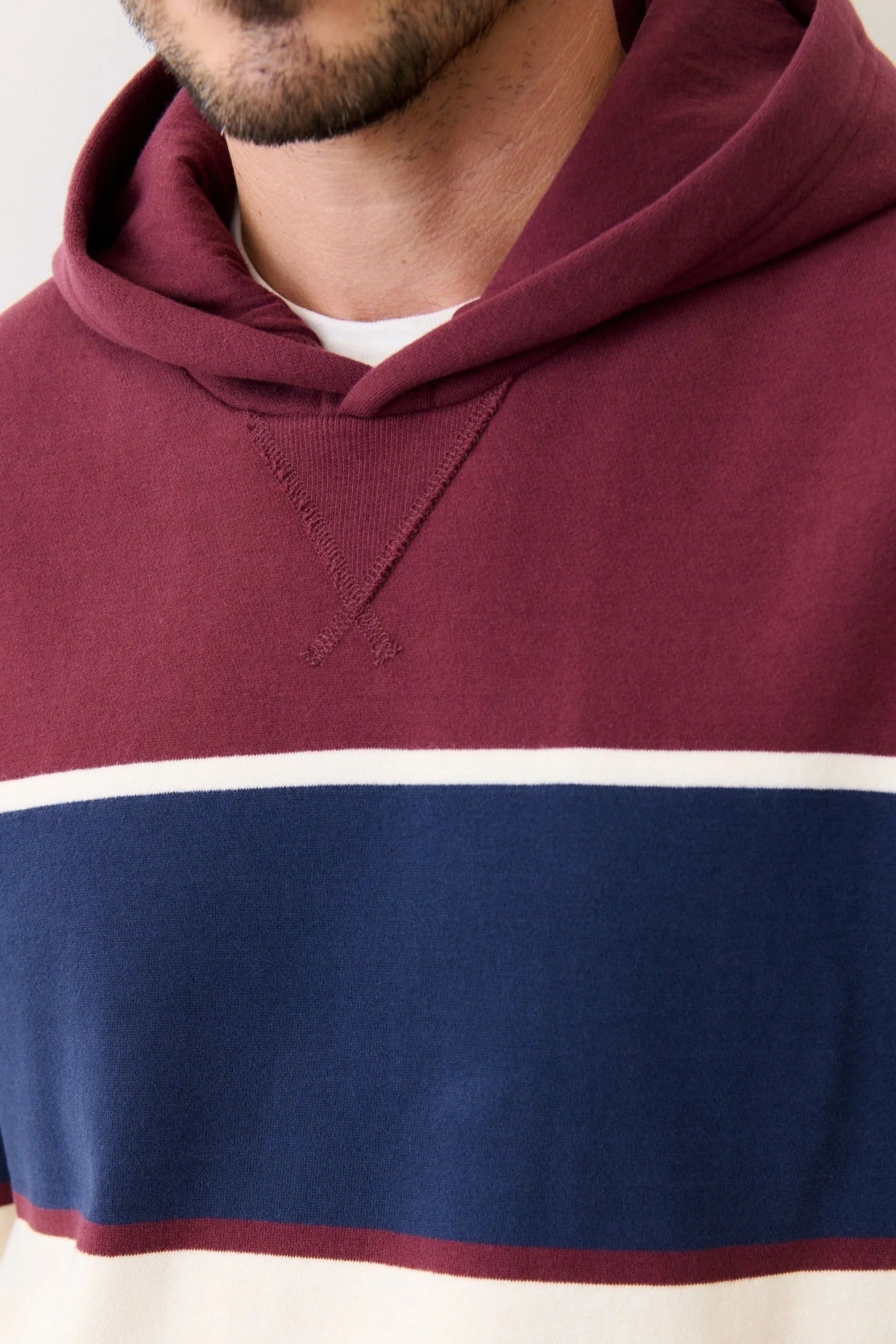 Maroon, blue, and white striped hoodie worn by a person